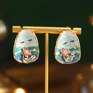Gros plan détaillé de boucles d'oreilles lotus en émail de style peinture de Monet