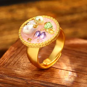 Detailed close-up of vintage baroque ring with natural pearl and floral enamel design