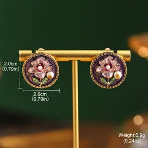 Macro detail of Monet-style floral stud earrings featuring natural pearls on a gold display stand