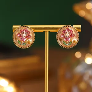 Detailed view of vintage enamel flower earrings with pearls on a gold stand.