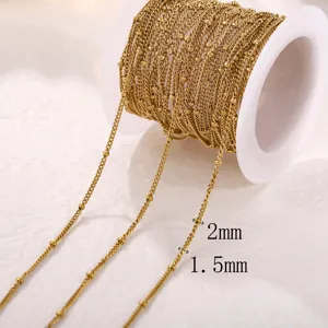 Detailed macro shot of a 1.5mm gold stainless steel curb chain with small 2mm beads