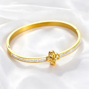 Close-up of a gold stainless steel bracelet with crystal inlay and flower motif