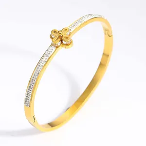 Detail shot of golden stainless steel bangle with pavé rhinestones and clover motif
