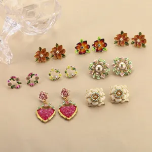 Detailansicht verschiedener Vintage-Emaille-Blumenohrringe mit Perlen und Herzanhängern.