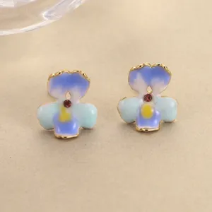 Detailed close-up showing the intricate blue gradient enamel work on these flower earrings