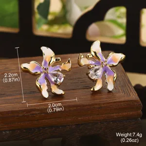Détail macro de boucles d'oreilles fleur émaillée avec taille 2,2 cm et poids 7,4 g.