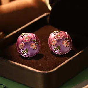 Macro view of vintage purple enamel earrings with delicate pink flower oil painting design