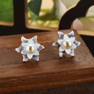 Vue détaillée des boucles d'oreilles fleurs en émail avec perle naturelle sur bois.