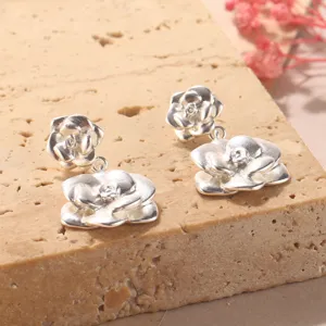 Vista dettagliata di orecchini a lobo a fiore 3D argento con una finitura opaca