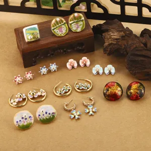 Vue détaillée de boucles d'oreilles artisanales en émail fleur avec perles nacrées