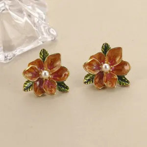 Detailansicht von Vintage-Emaille-Ohrringen in Blumenform mit einer zentralen Perle und Blättern