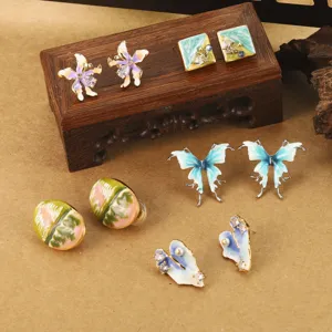 Vue détaillée de divers boutons d'oreilles artistiques en émail, papillon et fleur