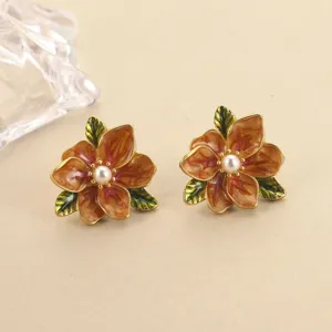 Detailansicht der Vintage-Emaille-Ohrringe in Blumenform mit Perle und grünen Blättern