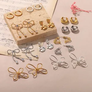 Varietà di orecchini metallici oro e argento con fiocchi e cuori su pietra