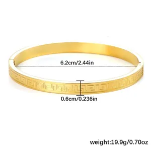 Vista dettagliata del motivo a chiave greca su questo bracciale rigido in oro 18 carats.