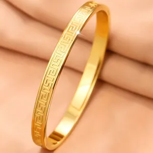 Primo piano dettagliato di bracciale in acciaio inossidabile placcato oro 18k con greca
