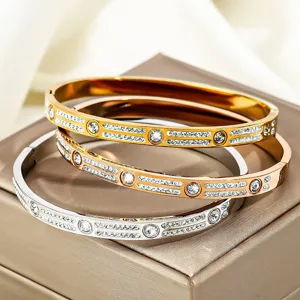 Nahaufnahme von Edelstahl-Armreifen mit zweireihigen Kristallen in Gold, Silber und Roségold.