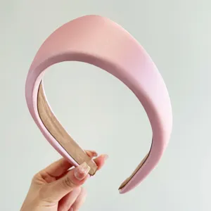 Primer plano de una diadema acolchada triangular rosa con textura satinada elegante