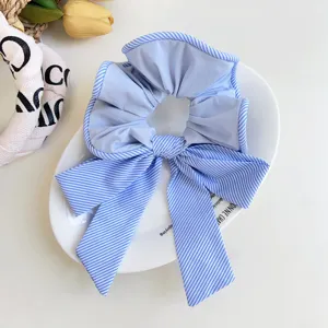 Primer plano de un coletero con lazo de tela a rayas azules y blancas en un plato.