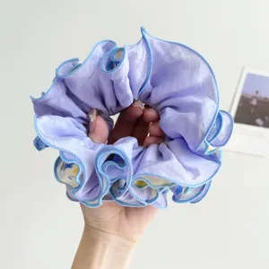 Macro view of purple oil painting pattern scrunchie with scalloped blue edges