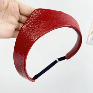 Close-up of red leather crown headband with textured finish and adjustable strap