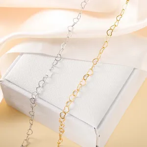Detailansicht von Herz-Armbändern aus Edelstahl in Silber und Gold auf einer Geschenkbox