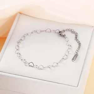 Detailansicht eines silbernen Herz-Edelstahlarmbands auf einer weißen Geschenkbox