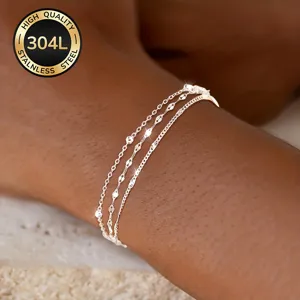 Close-up of three layered 304L stainless steel silver lip chain bracelets on wrist
