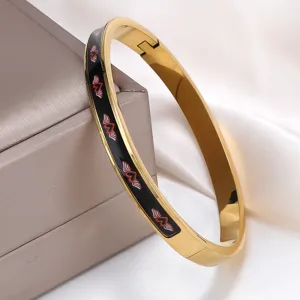 Detail eines Vintage 18K vergoldeten Edelstahlarmbands mit Herz-Flügel-Emaille