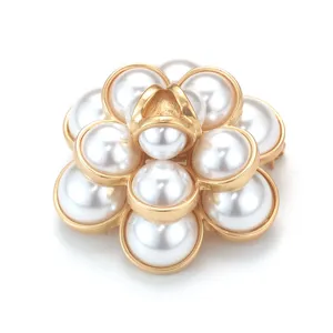 Close-up of elegant pearl camellia brooch with gold-tone finish for suit decoration.