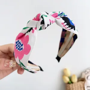 Gros plan d'un serre-tête large de style bohème avec broderie florale et nœud central