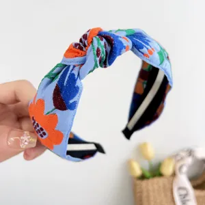 Vue détaillée d'un bandeau à nœud brodé bleu bohème avec des motifs floraux éclatants