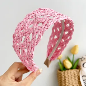 Close-up of pink wide woven rattan headband featuring a delicate hollow-out design