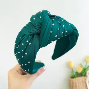 Detailopname van smaragdgroene geknoopte haarband met glinsterende strassteentjes