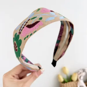 Vue détaillée du large serre-tête brodé de style bohème avec des motifs floraux colorés