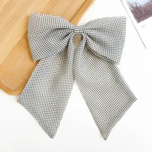 Vue détaillée d'une barrette à cheveux en forme de gros nœud à pois avec de longs rubans.