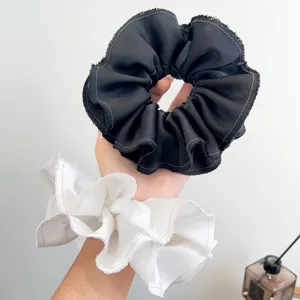 Set van twee oversized gegolfde scrunchies in zwart en wit met rafelranden