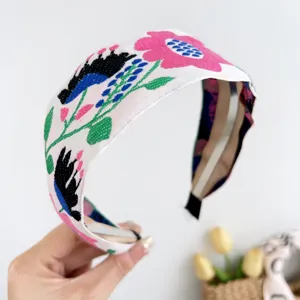 Gros plan sur un serre-tête large brodé de fleurs bohèmes avec texture tissée
