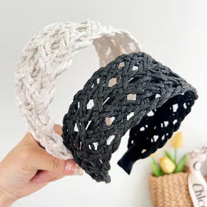 Detailed macro view of two wide braided straw headbands in cream and black colors.