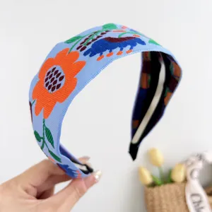 Gros plan sur un bandeau large brodé de style bohème avec des motifs floraux colorés