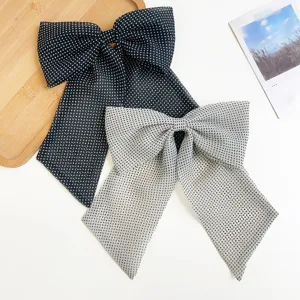 Vue détaillée du motif à pois et du tissu élégant sur les grandes barrettes à nœud