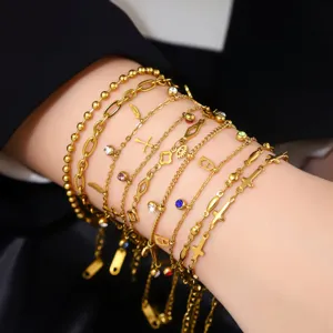 Detailansicht mehrerer 18K vergoldeter Edelstahl-Bettelarmbänder am Handgelenk einer Frau