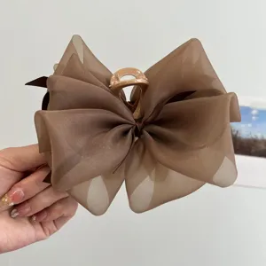 Detalle de pinza para el pelo con lazo de malla marrón y textura en capas de tela