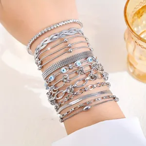 Nahaufnahme eines mehrlagigen silbernen Edelstahl-Armbandsets mit dem bösen Blick
