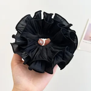 Nahaufnahme eines übergroßen schwarzen Organza-Haargummis mit elegantem Rüschendesign