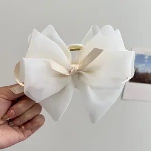 Primer plano de la pinza para el pelo con lazo grande de organza blanca y cinta