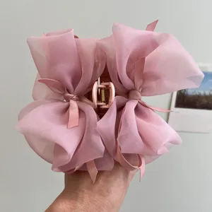 Vista detallada de una pinza para el pelo rosa con lazo de malla y textura suave