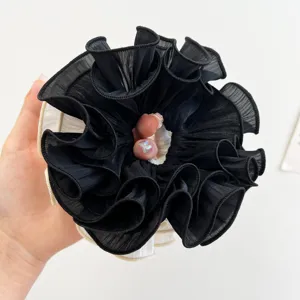Detailansicht eines großen schwarz-weißen plissierten Chiffon-Scrunchie