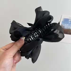 Primer plano detallado que muestra la elegante pinza para el pelo con lazo de malla negro