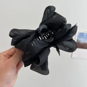 Primer plano de una pinza para el pelo con lazo de malla negra y textura suave